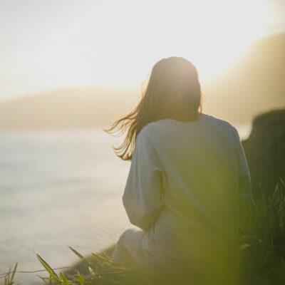 Woman sitting by the water